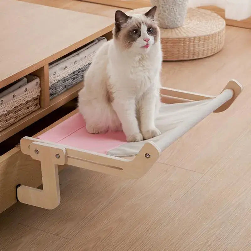 Chat profitant d’une table en bois avec un coussin rose dans Soft Hanging Hammock, vue suspendue