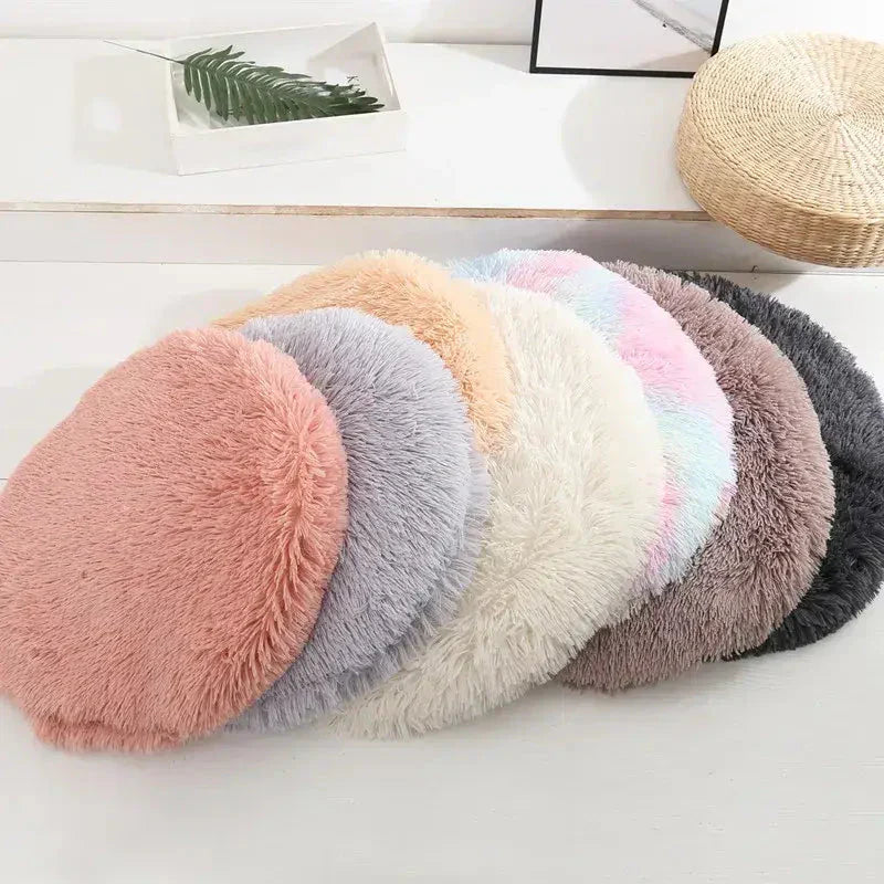 Lit rond pour petits animaux avec une pile de coussins en fourrure moelleux et doux